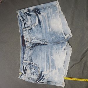 No Boundaries cut off shorts with studded accents and star print bleach design.